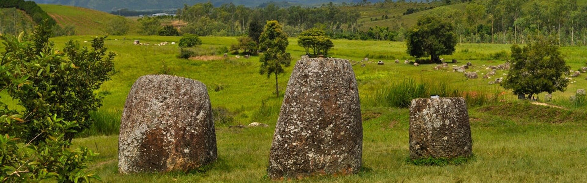 Xieng Khouang’s historic jar landscape at dusk on a Xieng Khouang Travel banner by Legend Travel Group.